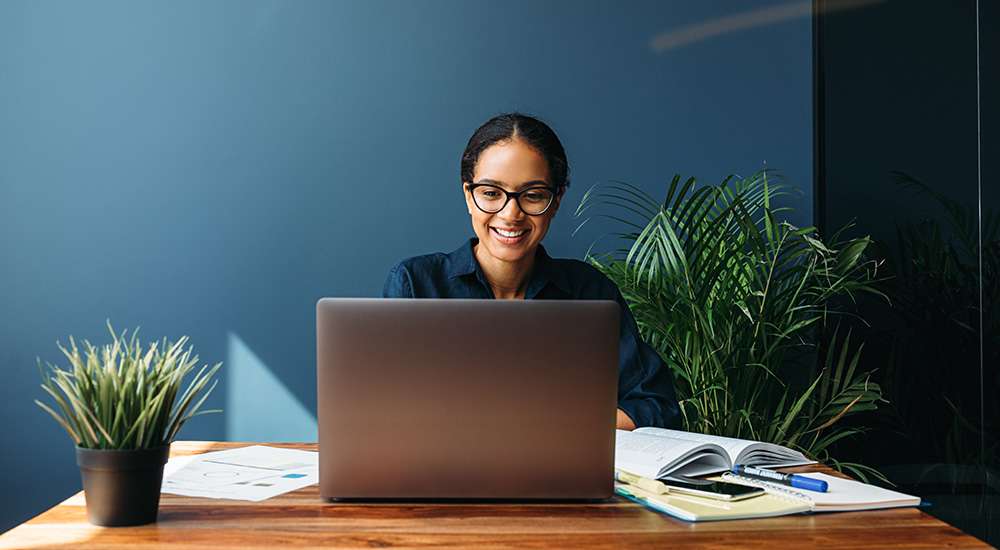 office worker sitting at her desk and smiling
